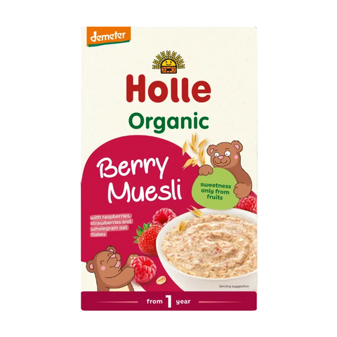 A box of Holle Organic Berry Muesli by Demeter, featuring a cream-colored background with red and green text, illustrations of cartoon bears, and a bowl of the muesli with berries on the front.
