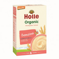 A box of Holle Organic Semolina Wholegrain Cereal for babies from 6 months, featuring a cream-colored box with red and green text, a bowl of cereal, and wheat illustrations.